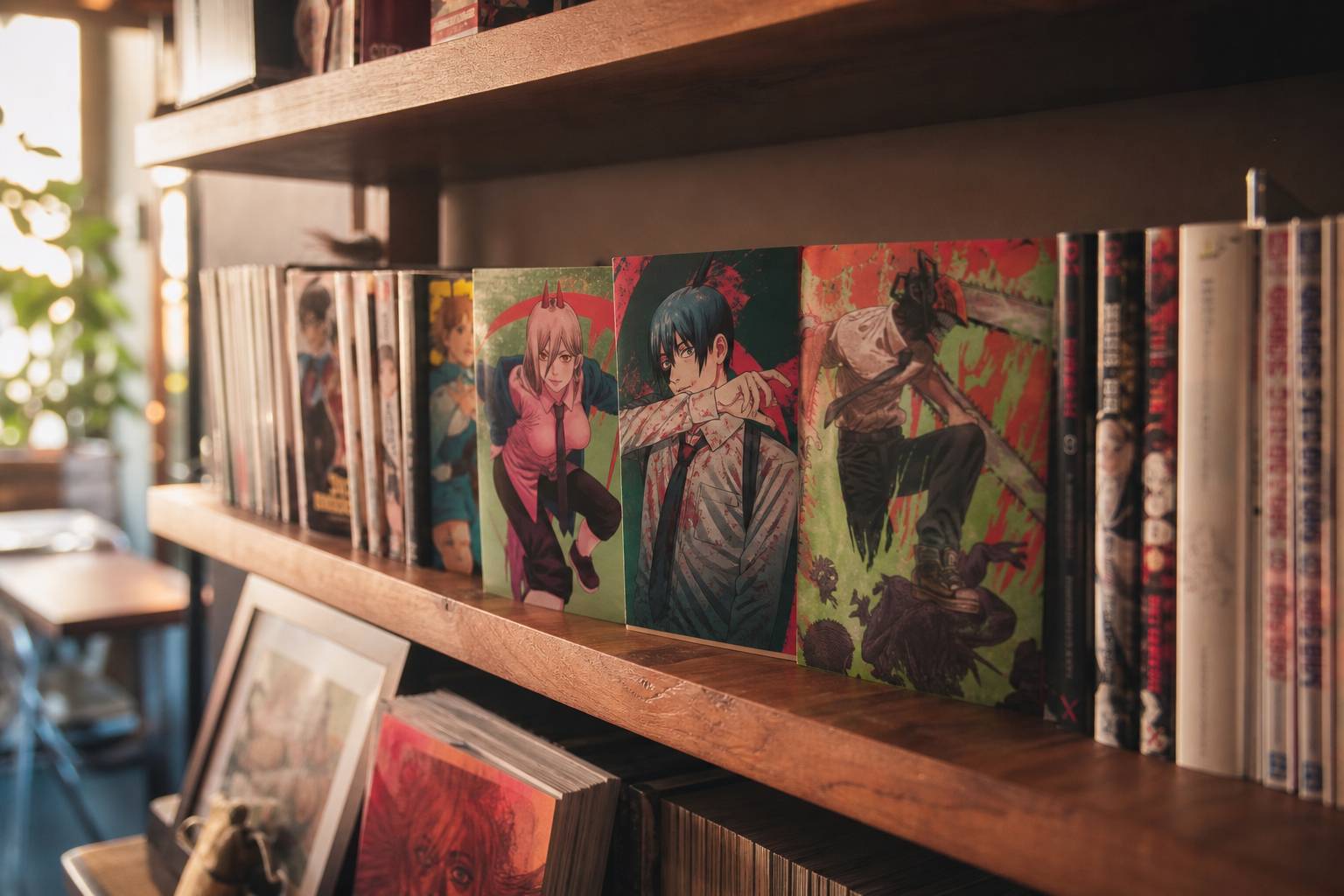 Collection de mangas Chainsaw Man sur une etagere avec eclairage chaleureux